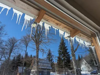 a view of icicles hanging from a window at Vikendica Brusnica