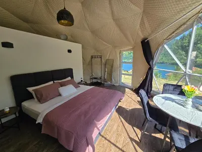 a bedroom in a tent with a bed and a table at Kamp Glamp Plivska Oaza in Jajce