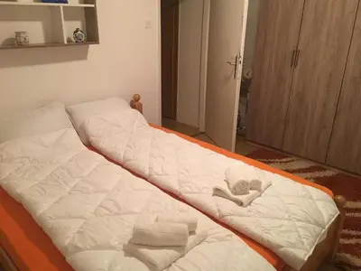 a bed with white sheets and towels on it at ZiiNa Skyline Apartment in Bihać