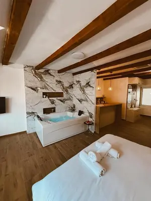 a bedroom with a tub and a bed with towels at RajRaj apartmani Gradiska in Bosanska Gradiška