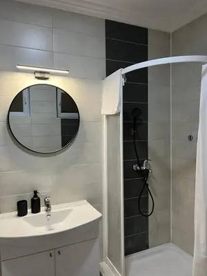 a bathroom with a shower and a sink and a mirror at RajRaj apartmani Gradiska in Bosanska Gradiška