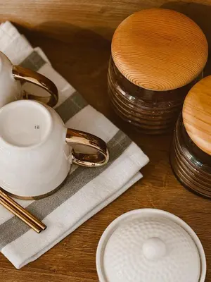 a wooden table with a tea pot and a stack of dishes at RajRaj apartmani Gradiska in Bosanska Gradiška
