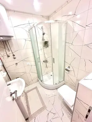 a white bathroom with a shower and a toilet at Apartment M&S in Bosanski Novi