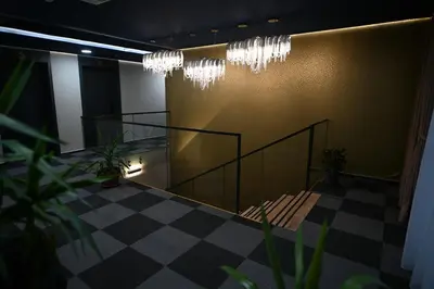 a lobby with a staircase and chandeliers at Hotel LOBBY PLUS in Bihać
