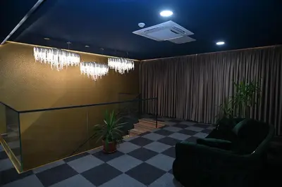 a lobby with two chairs and a ceiling with lights at Hotel LOBBY PLUS in Bihać