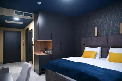 a bedroom with a bed with blue walls and yellow pillows at Hotel LOBBY PLUS in Bihać