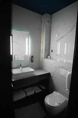 a white bathroom with a sink and a toilet at Hotel LOBBY PLUS in Bihać