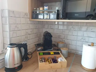 a table with a coffee maker and a microwave at City Vibe Apartment in Tuzla