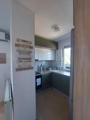 a kitchen with green cabinets and a counter top at City Vibe Apartment in Tuzla
