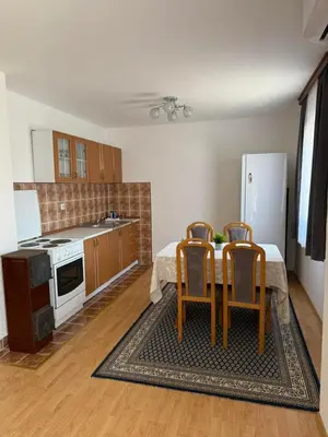 a kitchen with a table and chairs and a refrigerator at Dream house in Laktaši