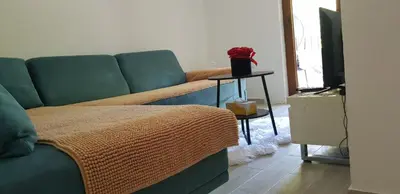 a living room with a couch and a table with a tv at Apartman M&B - Kuća za odmor-Karanovac in Topići