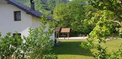 a building with a sign next to a yard at Apartman M&B - Kuća za odmor-Karanovac in Topići