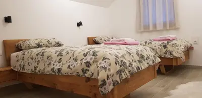 two beds in a bedroom with two pink towels on them at Apartman M&B - Kuća za odmor-Karanovac in Topići