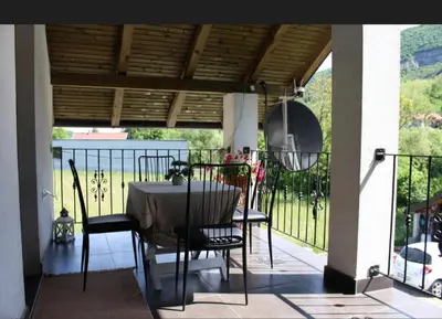 a porch with a table and chairs on a balcony at Apartman M&B - Kuća za odmor-Karanovac in Topići