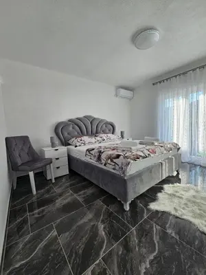 a bedroom with a large bed and a chair at Deluxe House Aqua Una in Otoka