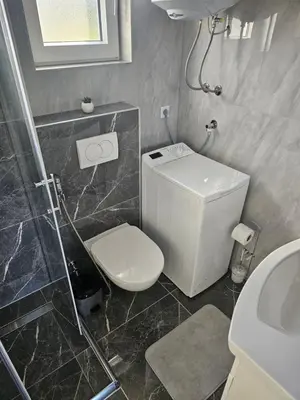 a bathroom with a toilet and a shower and a sink at Deluxe House Aqua Una in Otoka