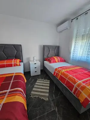 a bedroom with two beds and a night stand at Deluxe House Aqua Una in Otoka