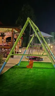 a swing set in a park with green grass at Ranc Cika Zlaje in Vitez