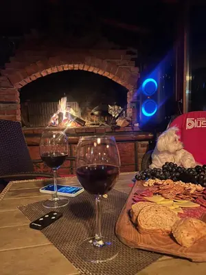 a table with two glasses of wine and a plate of food at Ranc Cika Zlaje in Vitez