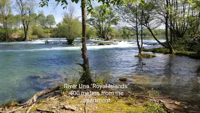 a river with rapids and trees and the words river under royal bands metres at Apartman EM-Bajkeraj in Bihać