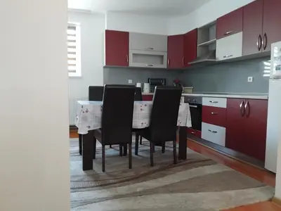 a kitchen with red cabinets and a table with chairs at Dinn in Jajce