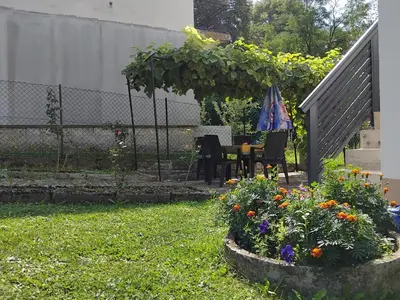 a garden with a table and chairs and flowers at Dinn in Jajce