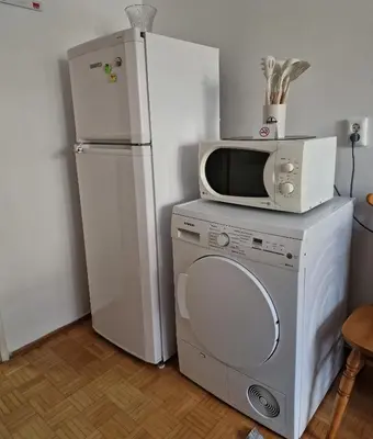 a microwave and a refrigerator in a kitchen at MI apartman in Tuzla