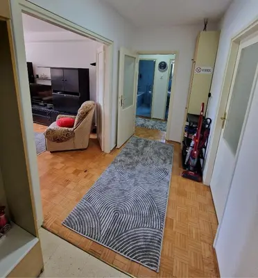 a living room with a rug on a wooden floor at MI apartman in Tuzla