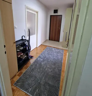 an empty room with a door and a rug at MI apartman in Tuzla