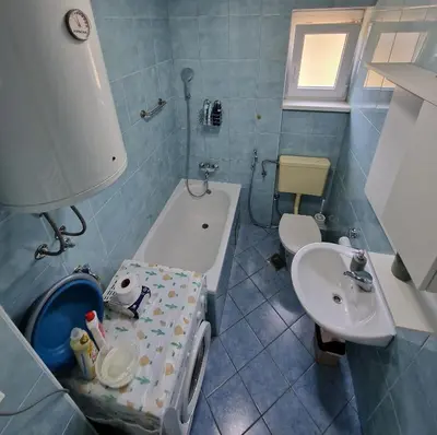 a bathroom with a toilet and a tub and a sink at MI apartman in Tuzla