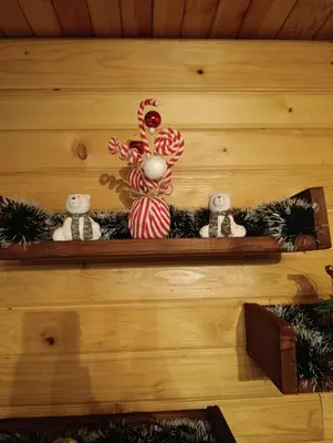 a shelf with christmas decorations on a wooden wall at Janjske Otoke Brvnara Tiho Ognjiste in Šipovo