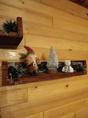 a shelf with christmas decorations on a wall at Janjske Otoke Brvnara Tiho Ognjiste in Šipovo