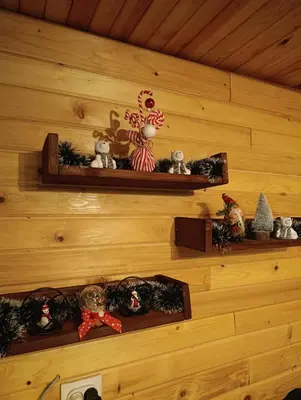 a wall with shelves with christmas ornaments on it at Janjske Otoke Brvnara Tiho Ognjiste in Šipovo