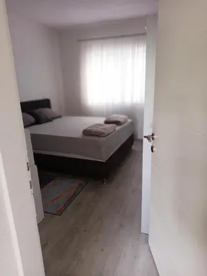 a small bedroom with a bed and a window at Apartman ARIS in Bosanska Krupa