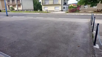 an empty street with a fence on the side of the road at Apartman ARIS in Bosanska Krupa