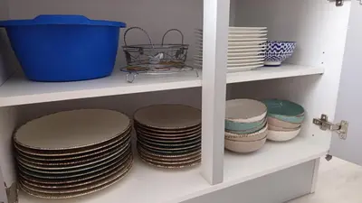 a stack of plates and bowls on a shelf at Apartman ARIS in Bosanska Krupa