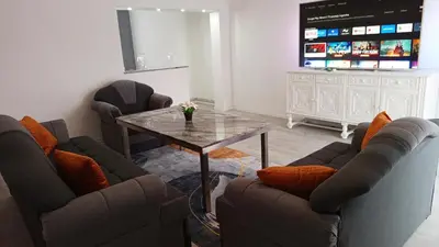a living room with couches and a table and a television at Apartman ARIS in Bosanska Krupa