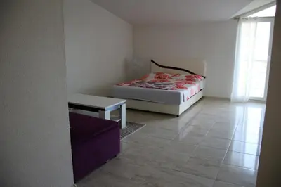 a bedroom with a bed and a table in it at Villa Leamax - Stan 9 in Velika Kladuša