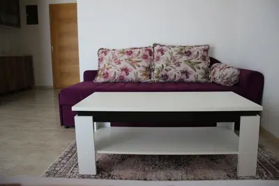 a purple couch with a white coffee table in a living room at Villa Leamax - Stan 9 in Velika Kladuša
