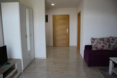 a living room with a couch and a wooden door at Villa Leamax - Stan 9 in Velika Kladuša
