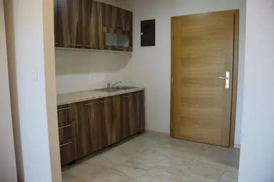 a kitchen with a sink and a wooden door at Villa Leamax - Stan 9 in Velika Kladuša