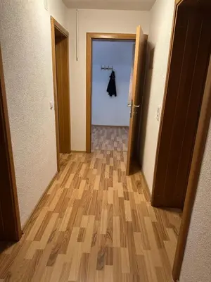 an empty hallway with a door and a coat hanging on a rack at Apartman Lida in Izačić