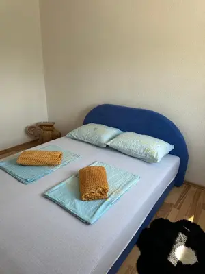 a blue bed with two pillows on top of it at Apartman Lida in Izačić