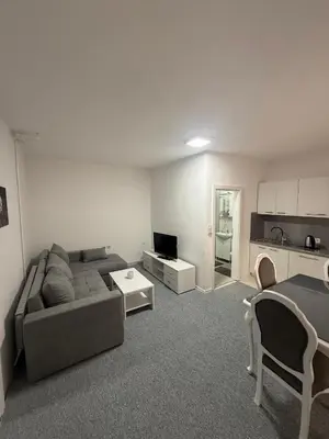a living room with a couch and a table at Renoviran i novo namješten Apartman in Velika Kladuša