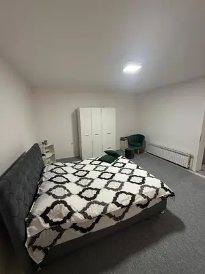 a bedroom with a bed with a black and white comforter at Renoviran i novo namješten Apartman in Velika Kladuša