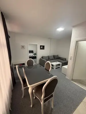 a living room with a table and chairs and a couch at Renoviran i novo namješten Apartman in Velika Kladuša