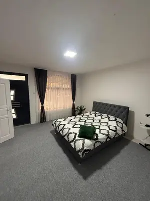 a bedroom with a bed with a green pillow on it at Renoviran i novo namješten Apartman in Velika Kladuša