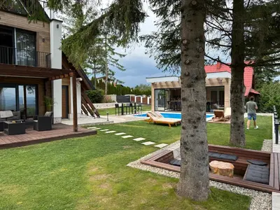 a backyard of a house with a tree at Mountain House LISINSKA ROSA in Brdo