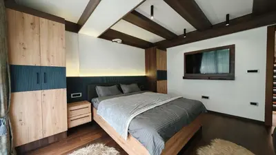 a bedroom with a bed and a tv on the wall at Mountain House LISINSKA ROSA in Brdo