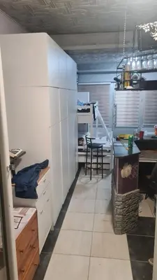 a kitchen with white cabinets and a table in it at Durmeo in Ripač
